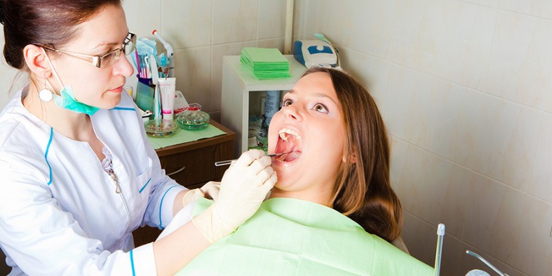 woman dentist making a review of patient mouth